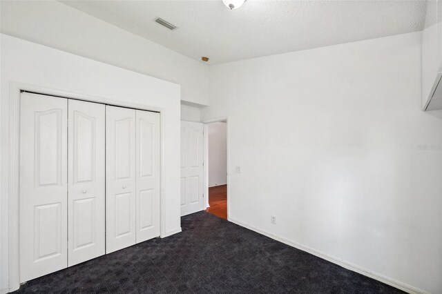 899 Addison Dr NE, Saint Petersburg, FL 33716 - unfurnished bedroom with dark carpet and a closet