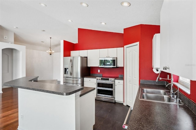 899 Addison Dr NE, Saint Petersburg, FL 33716 - kitchen with appliances with stainless steel finishes, dark countertops, white cabinets, high vaulted ceiling, and arched walkways
