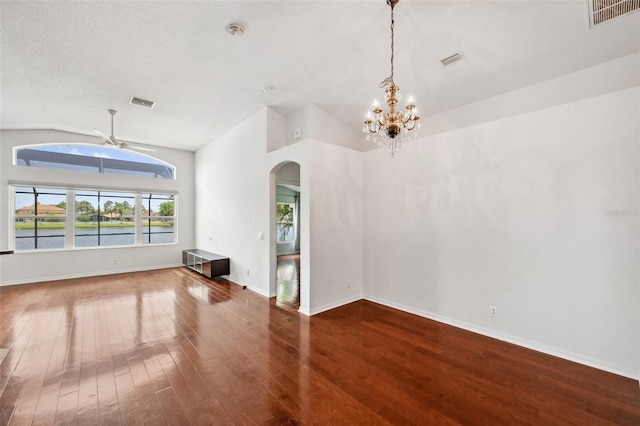 899 Addison Dr NE, Saint Petersburg, FL 33716 - unfurnished living room featuring arched walkways, vaulted ceiling, wood finished floors, a chandelier, and a water view