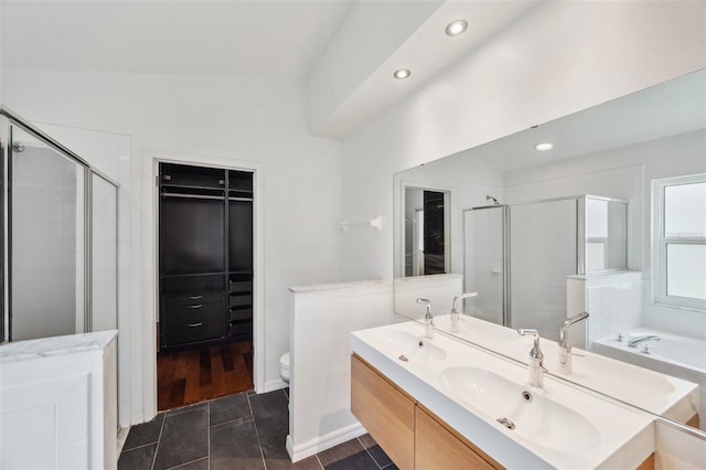 899 Addison Dr NE, Saint Petersburg, FL 33716 - full bath with a shower stall, double vanity, recessed lighting, a bath, and a walk in closet