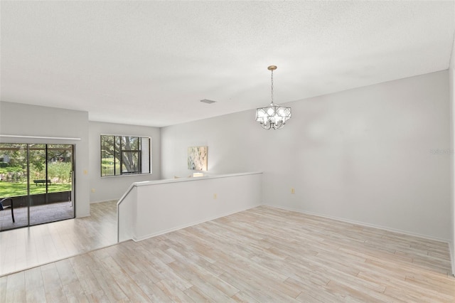 440 Lakeview Dr Unit 34, Palm Harbor, FL 34683 - spare room with wood finished floors, a chandelier, and a textured ceiling