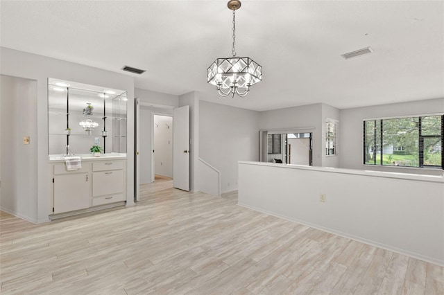 440 Lakeview Dr Unit 34, Palm Harbor, FL 34683 - unfurnished living room featuring a chandelier and light wood finished floors