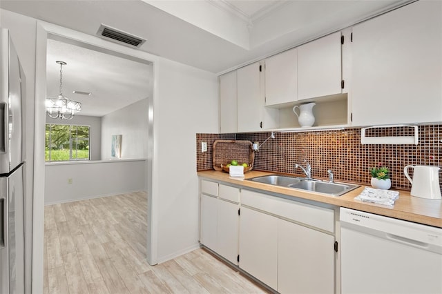 440 Lakeview Dr Unit 34, Palm Harbor, FL 34683 - kitchen featuring white dishwasher, freestanding refrigerator, tasteful backsplash, white cabinets, and crown molding