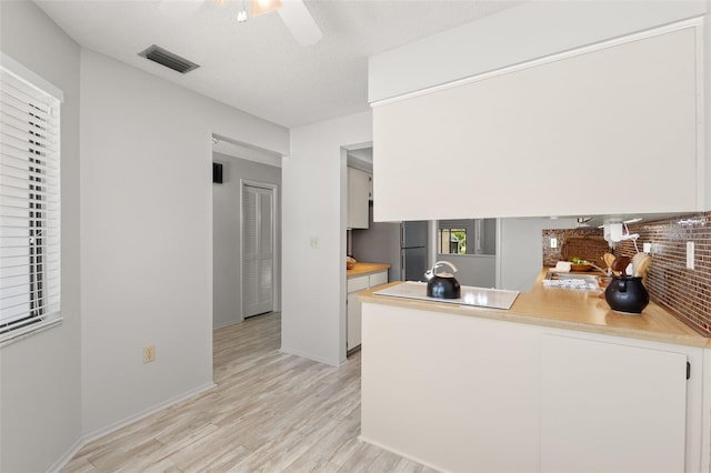 440 Lakeview Dr Unit 34, Palm Harbor, FL 34683 - kitchen featuring light wood finished floors, white cabinetry, a peninsula, and light countertops