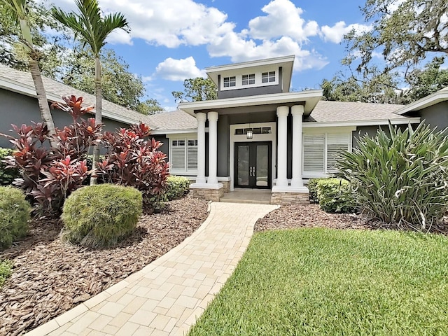 15024 Eaglepark Pl, Lithia, FL 33547 - view of front of home with french doors, a shingled roof, stucco siding, and a front lawn