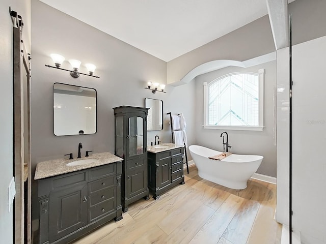 15024 Eaglepark Pl, Lithia, FL 33547 - full bath with wood finished floors, a freestanding bath, and two vanities