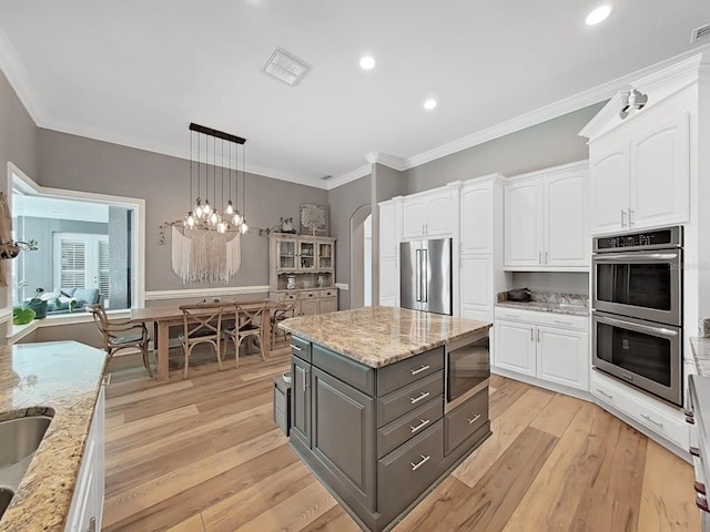 15024 Eaglepark Pl, Lithia, FL 33547 - kitchen with stainless steel appliances, gray cabinets, white cabinets, ornamental molding, and recessed lighting