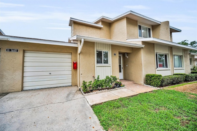 1660 Cape Ann Ave NE Unit 2, Saint Petersburg, FL 33702 - townhome / multi-family property featuring an attached garage, concrete driveway, and stucco siding