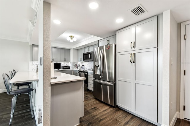 400 Island Way Unit 502, Clearwater Beach, FL 33767 - kitchen with stainless steel appliances, crown molding, a peninsula, recessed lighting, and dark wood-type flooring