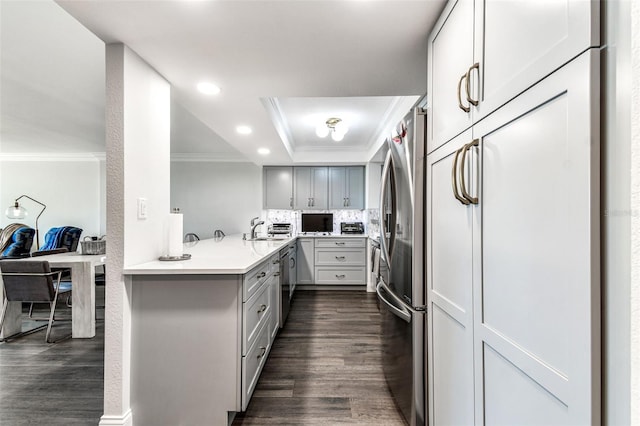 400 Island Way Unit 502, Clearwater Beach, FL 33767 - kitchen featuring a raised ceiling, ornamental molding, freestanding refrigerator, dark wood-type flooring, and light countertops