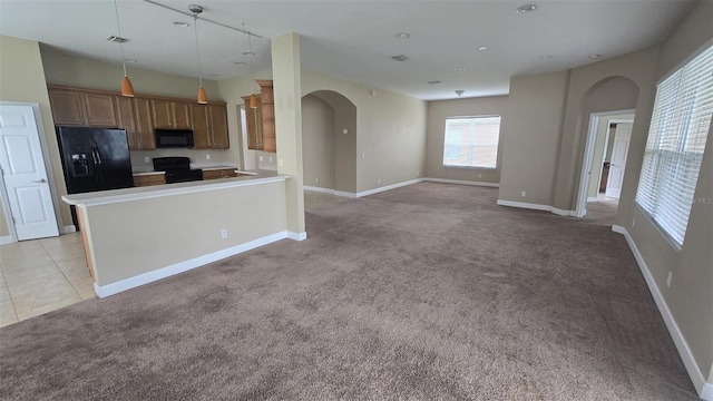 11341 Durham St, Parrish, FL 34219 - kitchen with black appliances, arched walkways, light carpet, decorative light fixtures, and a peninsula