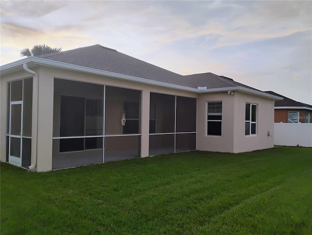 11341 Durham St, Parrish, FL 34219 - back of property at dusk featuring a sunroom and stucco siding