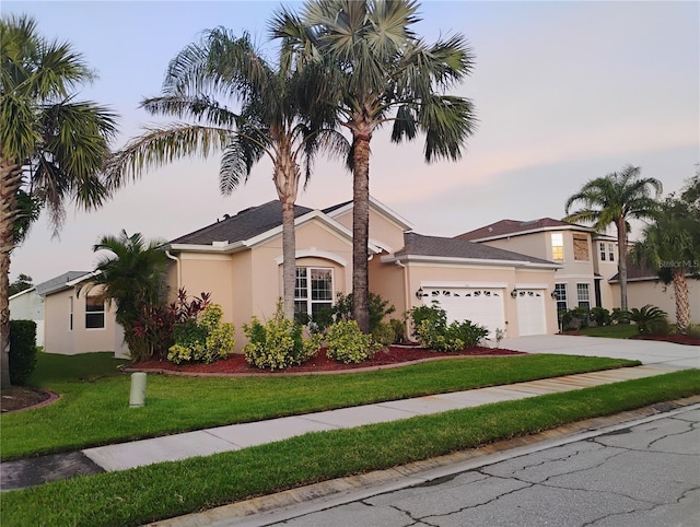 11341 Durham St, Parrish, FL 34219 - view of front of home with stucco siding, an attached garage, concrete driveway, and a lawn