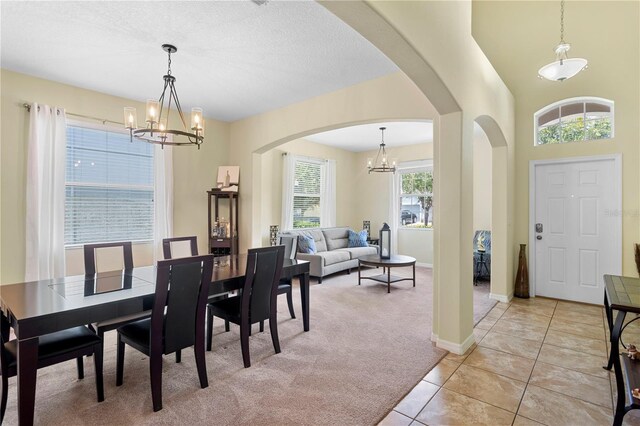 10216 Summer Azure Dr, Riverview, FL 33578 - dining room with a chandelier, arched walkways, light carpet, and light tile patterned floors