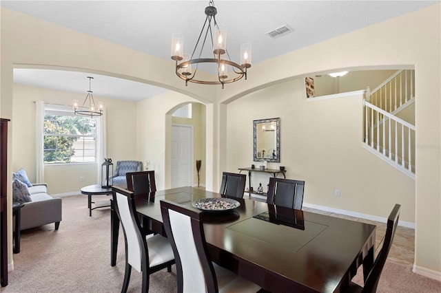 10216 Summer Azure Dr, Riverview, FL 33578 - dining room featuring a chandelier, arched walkways, light carpet, and stairs