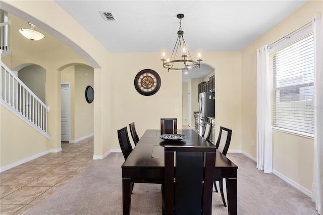 10216 Summer Azure Dr, Riverview, FL 33578 - dining area featuring a chandelier, arched walkways, and light carpet