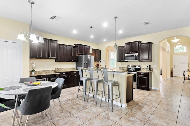 10216 Summer Azure Dr, Riverview, FL 33578 - kitchen featuring stainless steel appliances, arched walkways, plenty of natural light, a breakfast bar, and recessed lighting