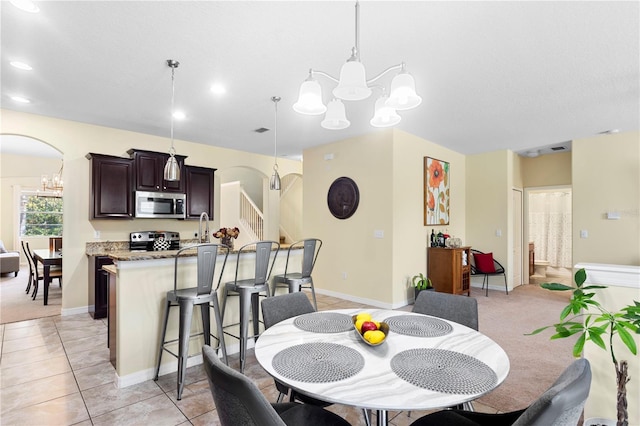 10216 Summer Azure Dr, Riverview, FL 33578 - dining area featuring a chandelier, arched walkways, stairs, and recessed lighting