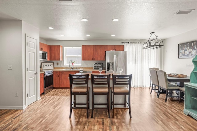 630 Mac Crillus Rd, Largo, FL 33770 - kitchen with stainless steel appliances, light countertops, light wood-style flooring, a textured ceiling, and recessed lighting