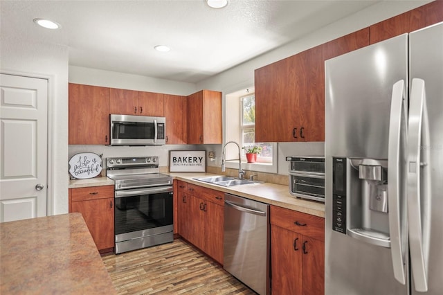 630 Mac Crillus Rd, Largo, FL 33770 - kitchen featuring stainless steel appliances, light countertops, light wood-style flooring, brown cabinetry, and recessed lighting
