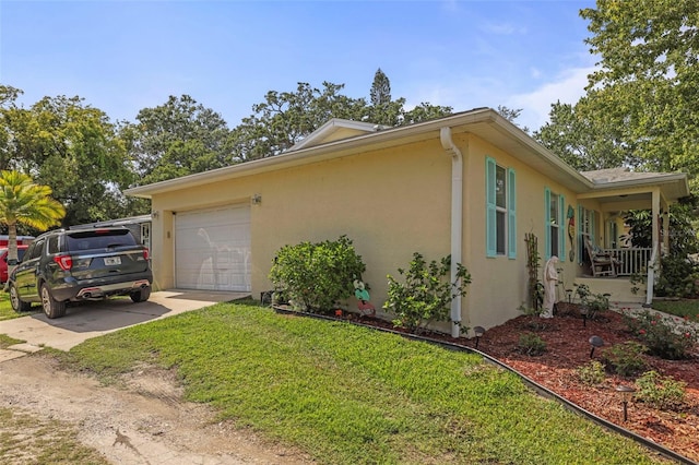 630 Mac Crillus Rd, Largo, FL 33770 - view of side of property with stucco siding, driveway, an attached garage, and a lawn