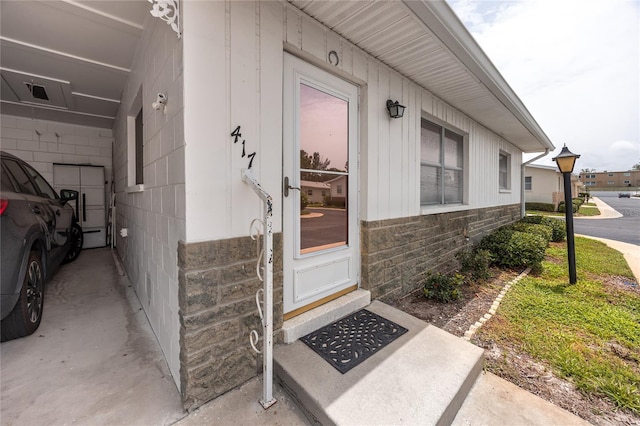 12400 Park Blvd Unit 417, Seminole, FL 33772 - doorway to property with stone siding and board and batten siding