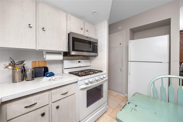 12400 Park Blvd Unit 417, Seminole, FL 33772 - kitchen featuring white appliances, light countertops, backsplash, and light tile patterned floors