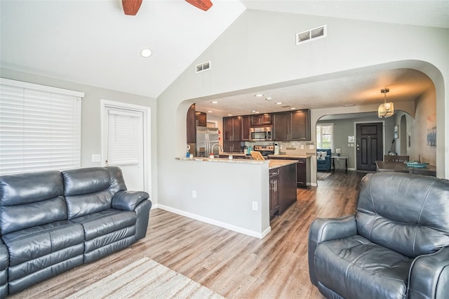 51 Cypress Dr, Palm Harbor, FL 34684 - living area with arched walkways, wood finished floors, a ceiling fan, vaulted ceiling, and recessed lighting