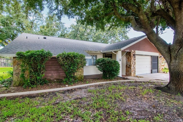 8626 Woodbridge Dr, New Port Richey, FL 34655 - ranch-style home featuring stone siding, roof with shingles, a garage, and concrete driveway