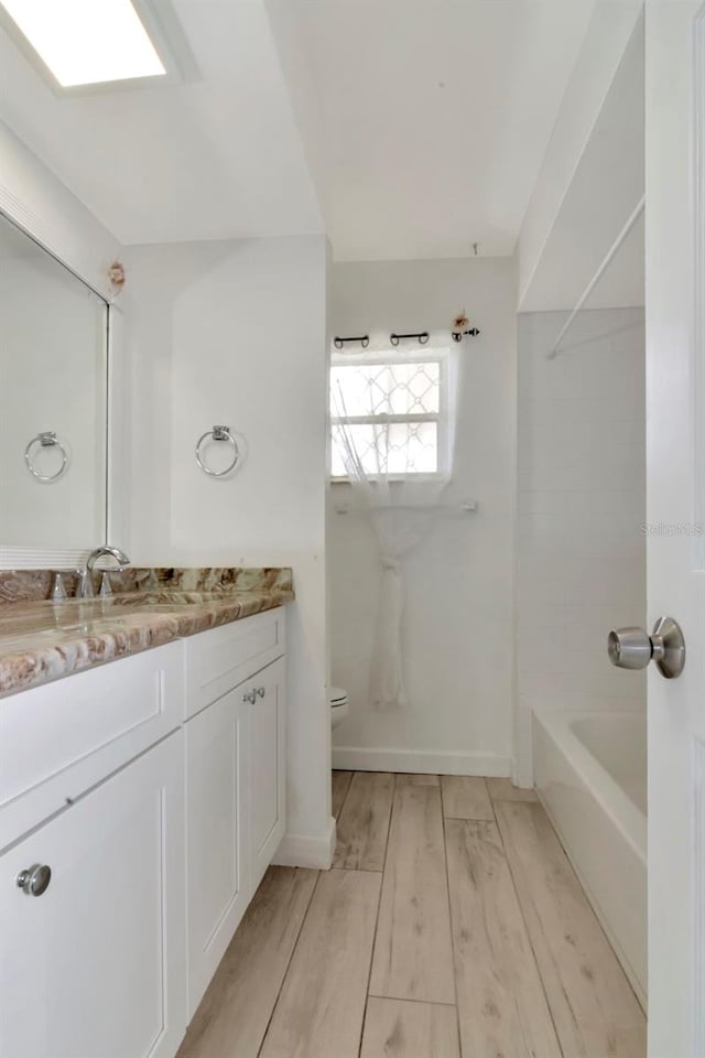 8626 Woodbridge Dr, New Port Richey, FL 34655 - bathroom featuring vanity, wood finished floors, and shower / bathtub combination