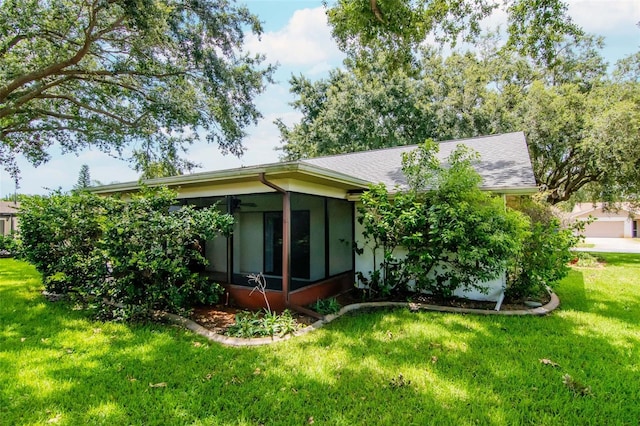 8626 Woodbridge Dr, New Port Richey, FL 34655 - back of house with a sunroom and a lawn