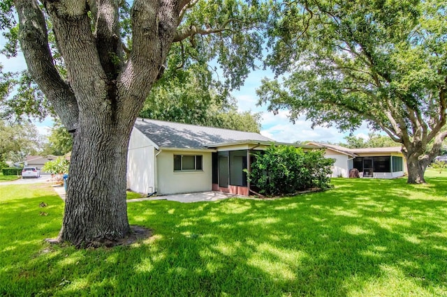 8626 Woodbridge Dr, New Port Richey, FL 34655 - back of house with a yard and a sunroom