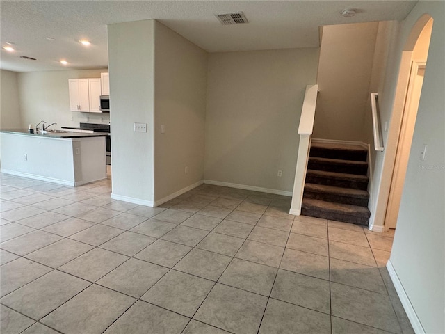 4448 Globe Thistle, Tampa, FL 33619 - unfurnished living room featuring light tile patterned floors, recessed lighting, stairway, and arched walkways