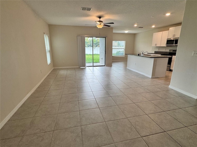 4448 Globe Thistle, Tampa, FL 33619 - kitchen featuring stainless steel appliances, open floor plan, dark countertops, ceiling fan, and a textured ceiling