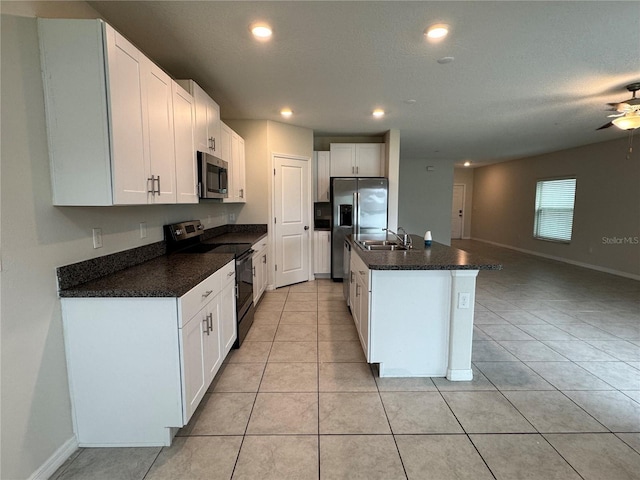 4448 Globe Thistle, Tampa, FL 33619 - kitchen featuring appliances with stainless steel finishes, white cabinetry, light tile patterned floors, an island with sink, and recessed lighting