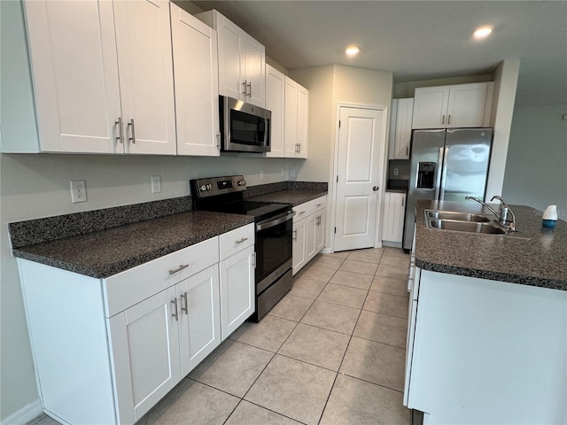 4448 Globe Thistle, Tampa, FL 33619 - kitchen featuring appliances with stainless steel finishes, white cabinets, dark countertops, light tile patterned flooring, and recessed lighting