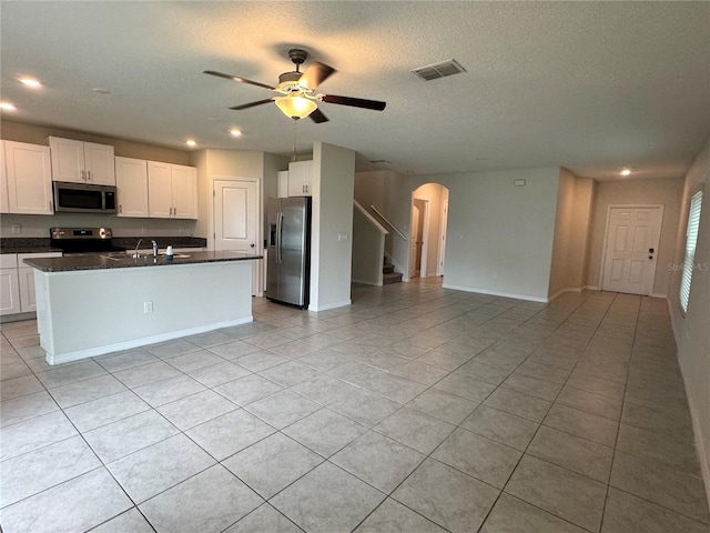 4448 Globe Thistle, Tampa, FL 33619 - kitchen featuring appliances with stainless steel finishes, arched walkways, light tile patterned floors, open floor plan, and white cabinetry