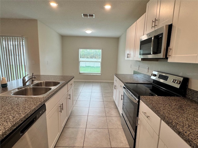4448 Globe Thistle, Tampa, FL 33619 - kitchen with appliances with stainless steel finishes, dark countertops, white cabinets, light tile patterned floors, and recessed lighting