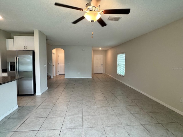 4448 Globe Thistle, Tampa, FL 33619 - unfurnished living room featuring arched walkways, ceiling fan, a textured ceiling, and light tile patterned floors