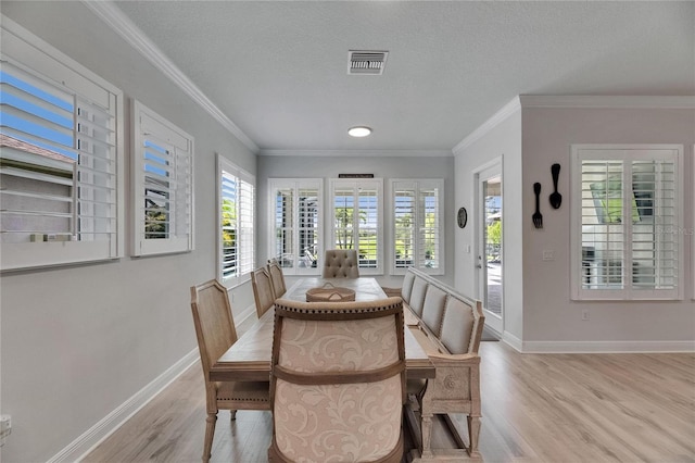 7420 Paradiso Dr, Apollo Beach, FL 33572 - dining room with light wood-style flooring, ornamental molding, and a textured ceiling