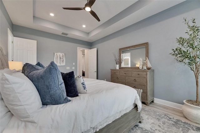 7420 Paradiso Dr, Apollo Beach, FL 33572 - bedroom featuring light wood finished floors, ceiling fan, recessed lighting, and a raised ceiling