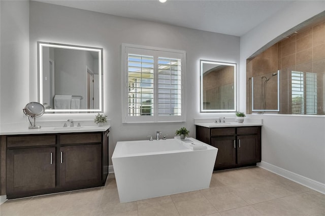 7420 Paradiso Dr, Apollo Beach, FL 33572 - full bathroom featuring a soaking tub, two vanities, tiled shower, and tile patterned floors