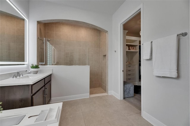 7420 Paradiso Dr, Apollo Beach, FL 33572 - bathroom featuring vanity, a walk in shower, tile patterned flooring, and a walk in closet