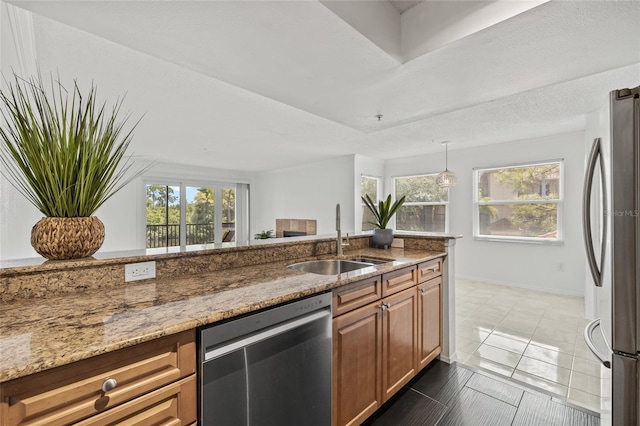 2400 Feather Sound Dr Unit 528, Clearwater, FL 33762 - kitchen with appliances with stainless steel finishes, light stone countertops, brown cabinetry, and healthy amount of natural light