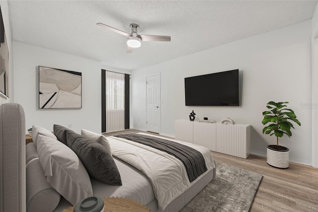 2400 Feather Sound Dr Unit 528, Clearwater, FL 33762 - bedroom featuring light wood-type flooring, a textured ceiling, and ceiling fan