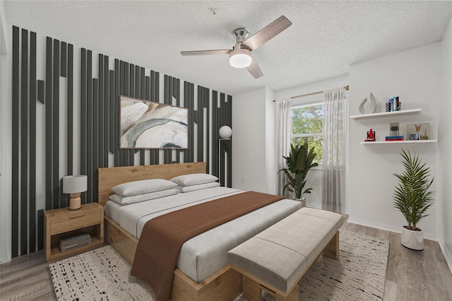 2400 Feather Sound Dr Unit 528, Clearwater, FL 33762 - bedroom featuring a textured ceiling, light wood-style flooring, and ceiling fan