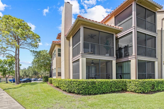 2400 Feather Sound Dr Unit 528, Clearwater, FL 33762 - view of home's exterior featuring a tiled roof, a sunroom, and a ceiling fan