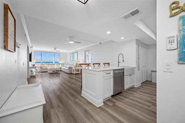 6372 Palma Del Mar Blvd S Unit 601, Saint Petersburg, FL 33715 - kitchen with stainless steel dishwasher, white cabinets, dark wood-type flooring, light countertops, and open floor plan