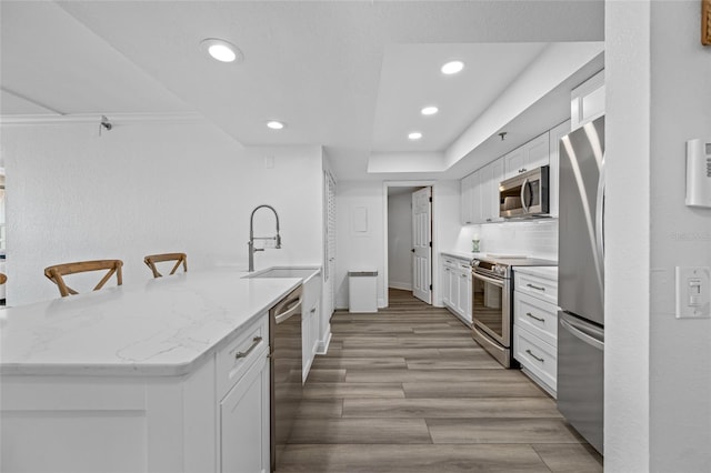 6372 Palma Del Mar Blvd S Unit 601, Saint Petersburg, FL 33715 - kitchen with appliances with stainless steel finishes, recessed lighting, white cabinetry, light wood finished floors, and a peninsula