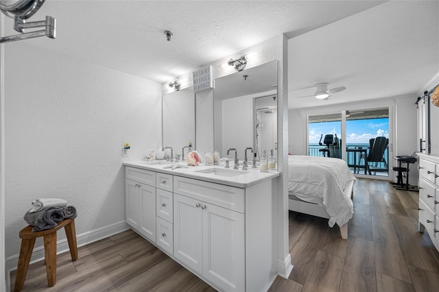 6372 Palma Del Mar Blvd S Unit 601, Saint Petersburg, FL 33715 - bathroom featuring double vanity, wood finished floors, a textured wall, a textured ceiling, and a ceiling fan